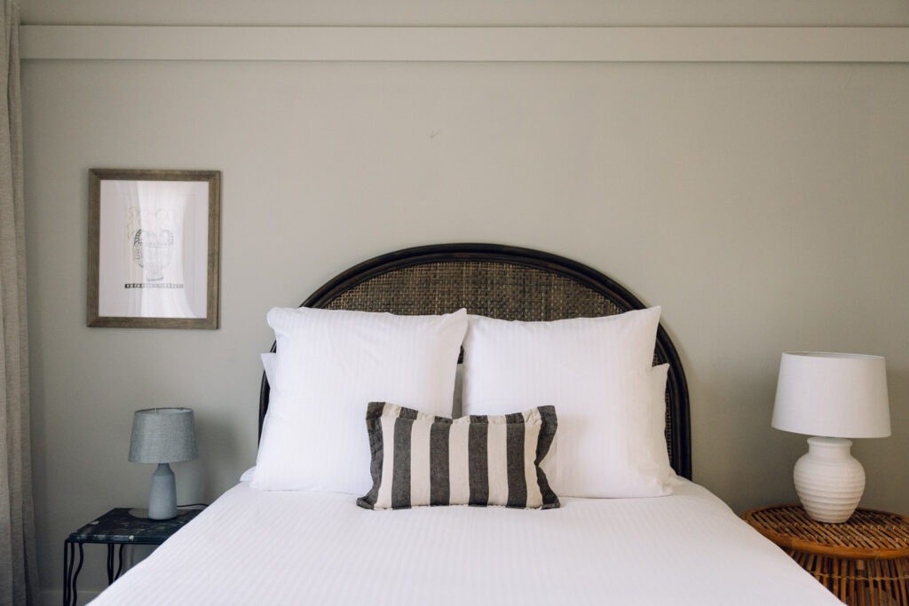 Wilkinson Room Superior bed with white linen and striped cushion